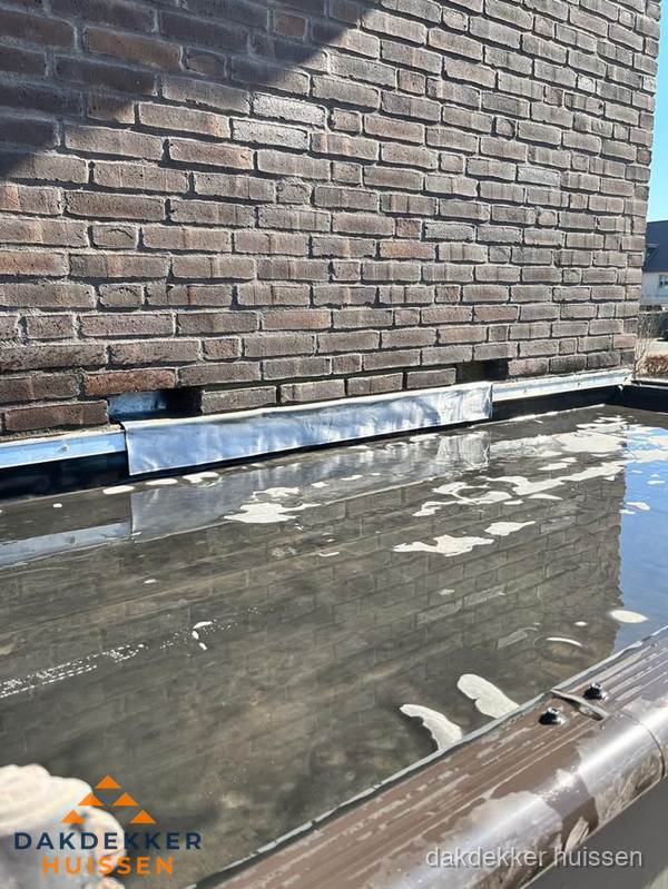 Stilstaand water op plat dak door slechte afwatering in Huissen Stilstaand water op plat dak door slechte afwatering in Huissen